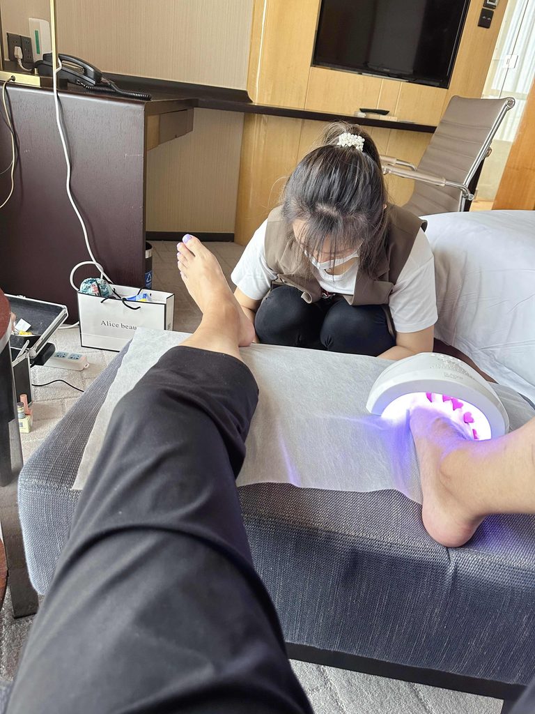 美女美甲师给男生修剪脚趾甲 / Female nail technician trimming a man's toenails