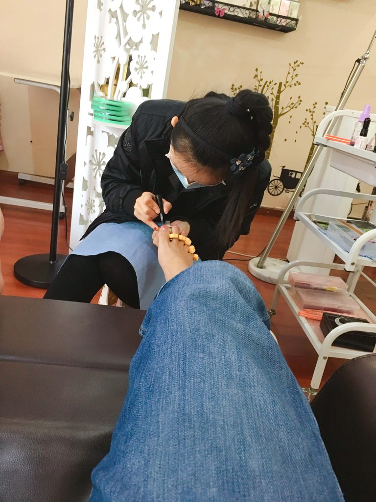 美甲师给男生脚趾甲修型 / Nail technician shaping a man's toenails
